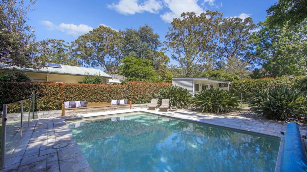 a swimming pool in the backyard of a house at Casa Bianca - Pearl Beach in Pearl Beach