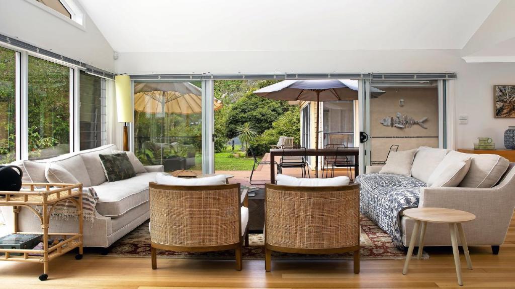 ein Wohnzimmer mit Couch und Stühlen in der Unterkunft Paradise - Pearl - Modern With Wifi in Pearl Beach