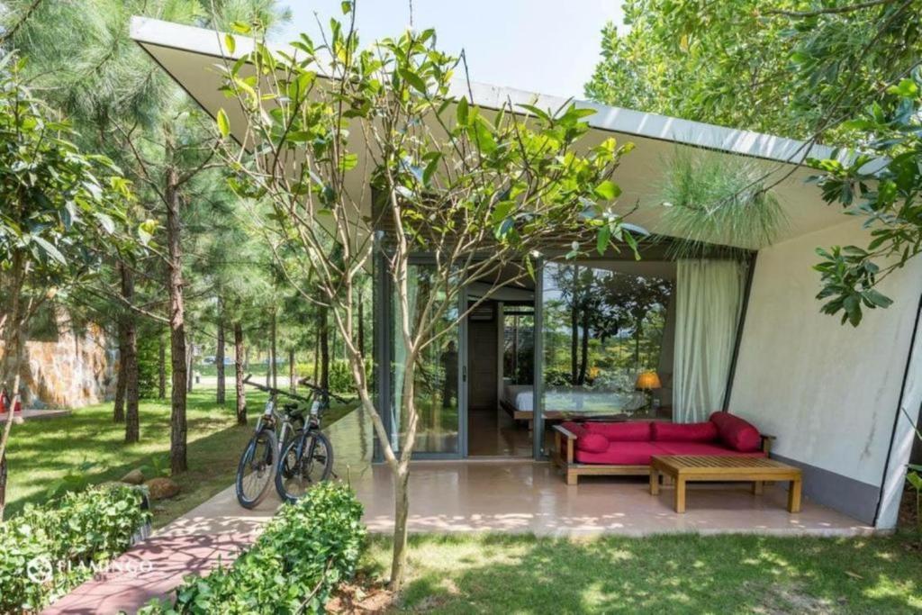 a house with a pink couch in a yard at Đại Lải Resort - Lake view villa in Phúc Yên