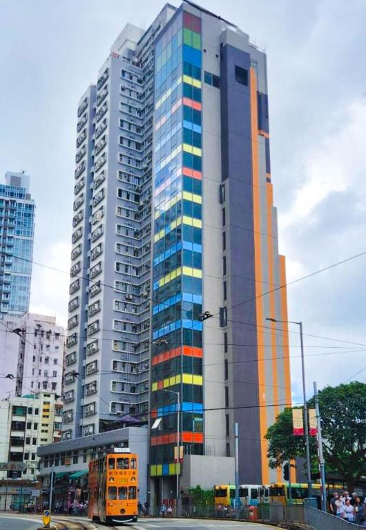 uno scuolabus parcheggiato di fronte a un palazzo alto di China Rich Oriental Hotel a Hong Kong