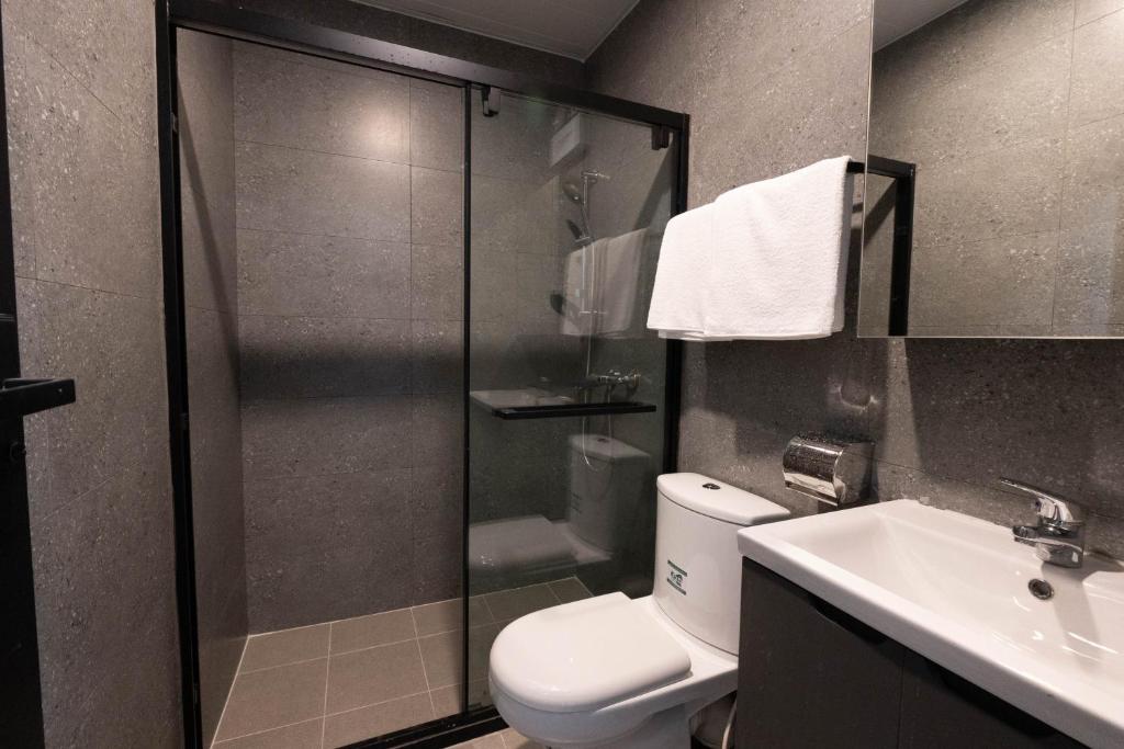un bagno con doccia, WC e lavandino di China Rich Oriental Hotel a Hong Kong