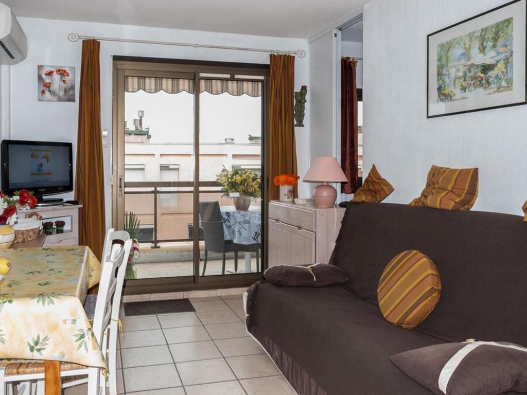 un salon avec un canapé et une table dans l'établissement 2 Pièces au Centre Ville, 4 Couchages, Proche Plage, Terrasse, Clim, Parking - FR-1-803-65, au Lavandou