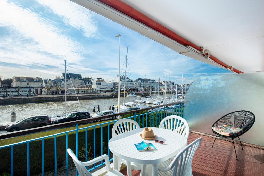 un balcon avec une table et des chaises et une vue sur un port dans l'établissement Superbe appartement et vue - 4 pers - Parking, à La Baule