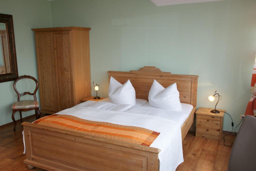 a bedroom with a large bed with white sheets and pillows at Ferienwohnungen im Haus Bi Henny in Baabe