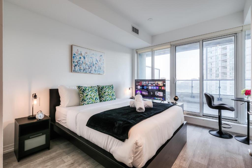 a bedroom with a large bed and a window at RivetStays - The Jarvis in Toronto