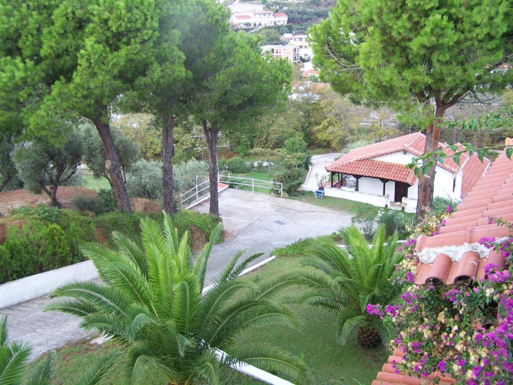 a view of a park with trees and flowers at Villa Anna Maria in Agia Paraskevi