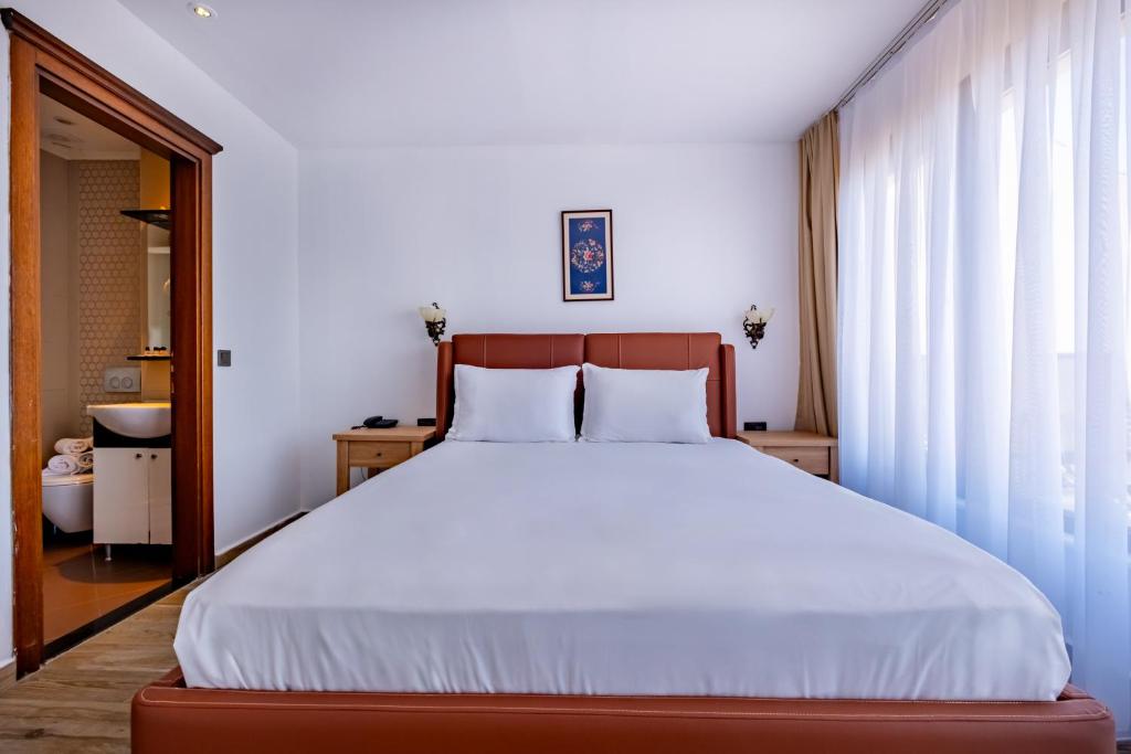 A bed or beds in a room at Mangana Konak Hotel