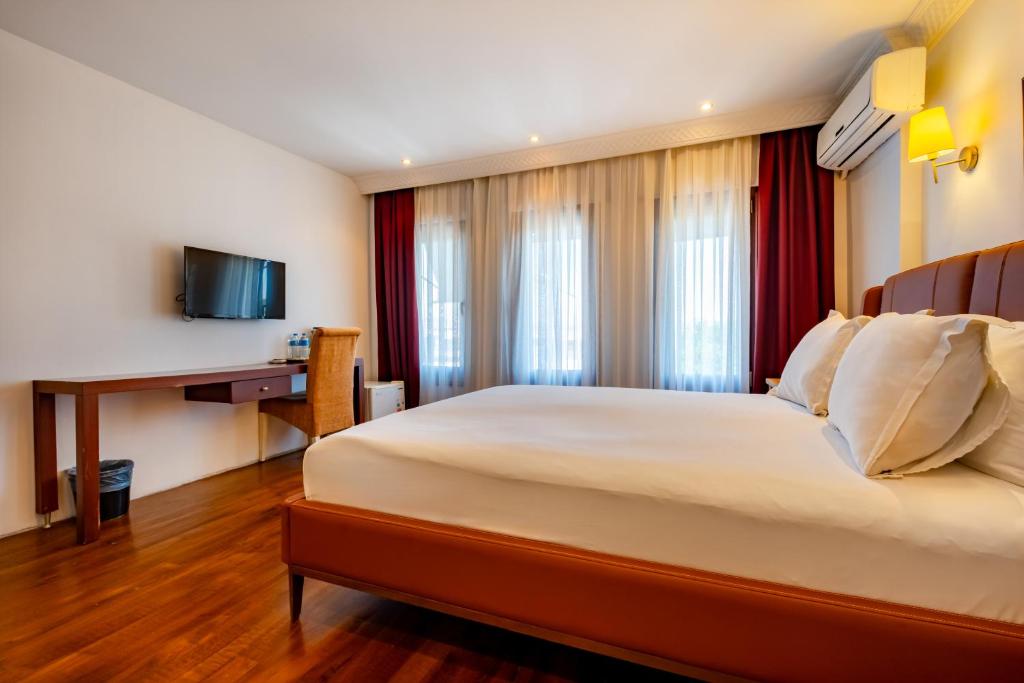A bed or beds in a room at Mangana Konak Hotel