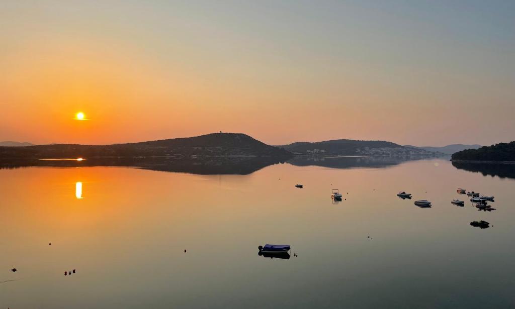 a group of boats on a lake at sunset at Luxury apartment Betina in Betina