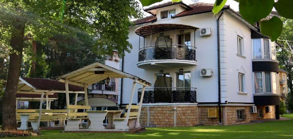 una casa bianca con un balcone sul lato di Anastasija Sobe AS a Vrnjačka Banja