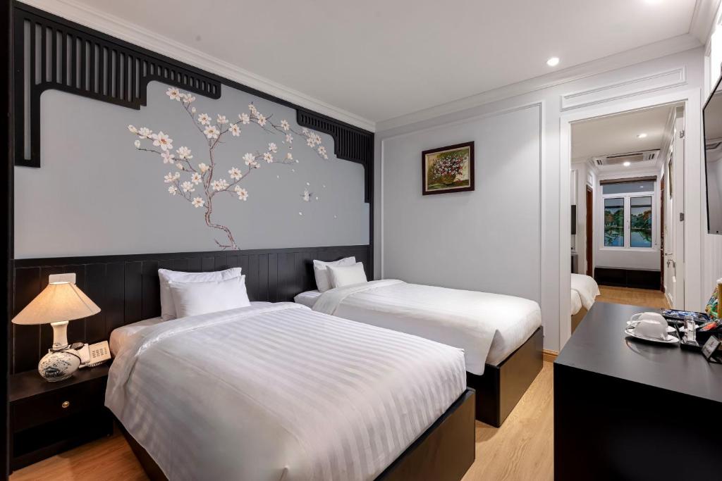 Postel nebo postele na pokoji v ubytování Serenata San de Hanoi Hotel
