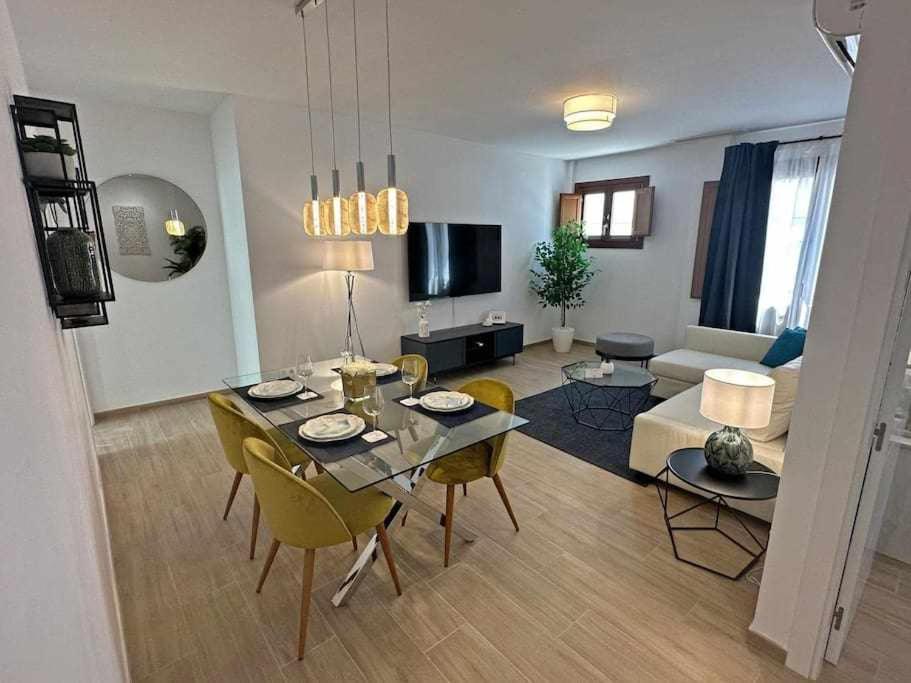 a living room with a table and chairs in a living room at XXII Apartamentos Morales&Arnal in Estepona