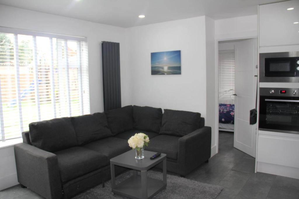 a living room with a couch and a table at 3 Bed house walking distance to Central line in Woodford Green