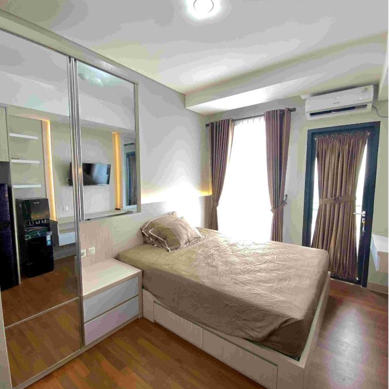 a bedroom with a bed and a large window at Kyra Property in Pegadungan