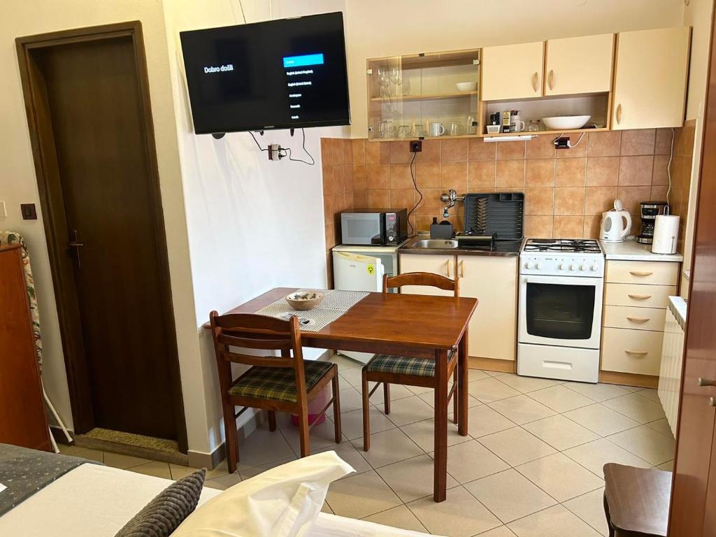 a kitchen with a table and chairs and a stove and oven at Apartment studio Rosi 1, with free public parking in a quiet location in Pula