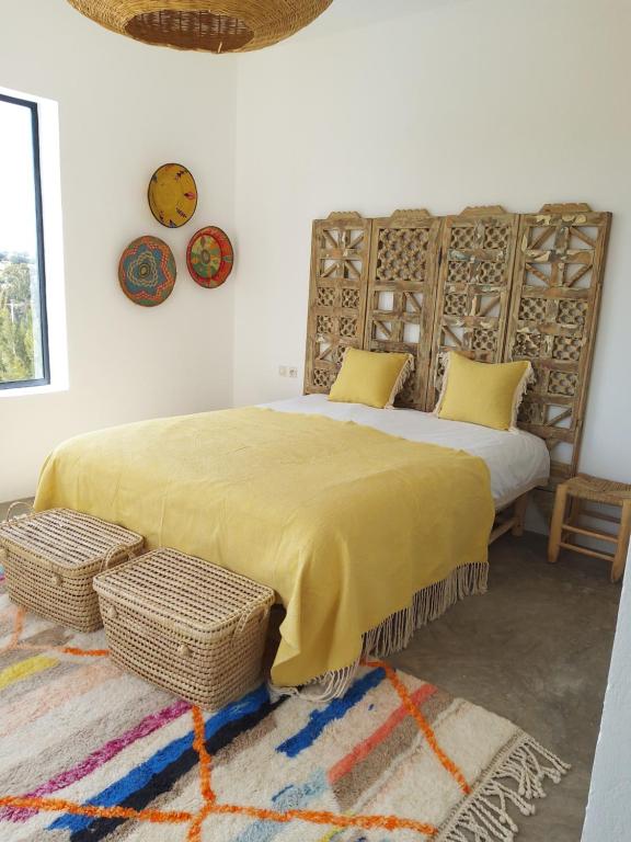 une chambre avec un grand lit avec une couverture jaune dans l'établissement Villa Bohèmia, à Essaouira