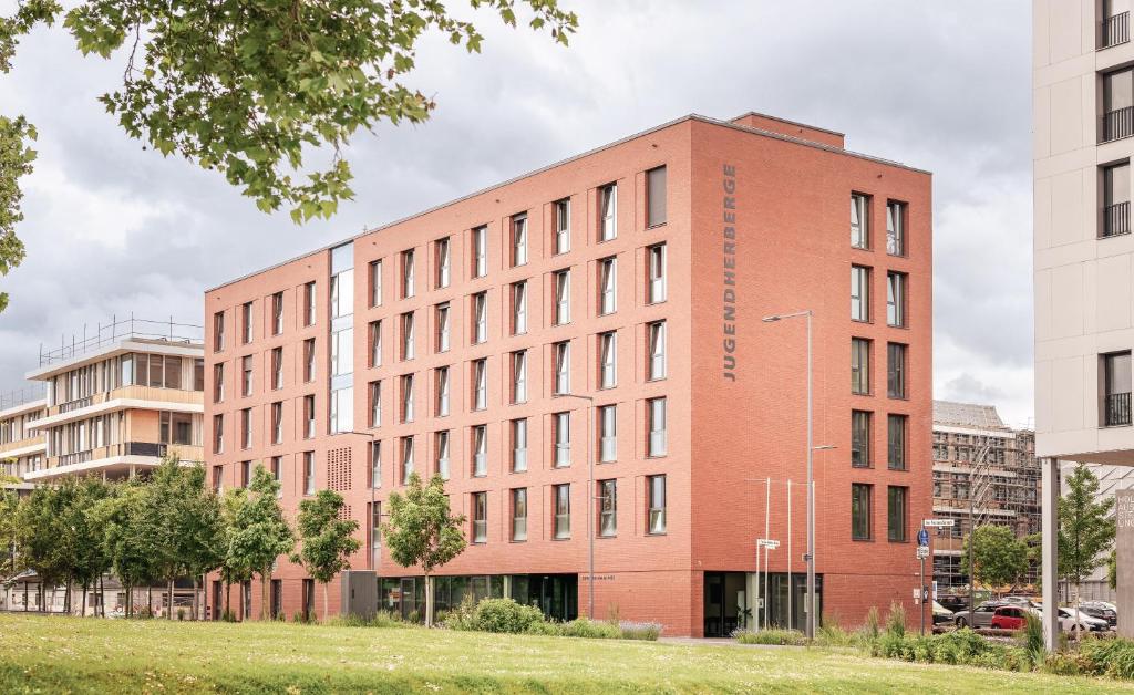 a large red brick building in a city at Jugendherberge Heilbronn in Heilbronn