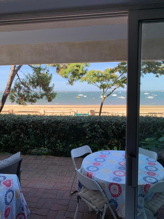 - une table et des chaises sur une terrasse avec vue sur la plage dans l'établissement Arcachon bord de plage, à Arcachon