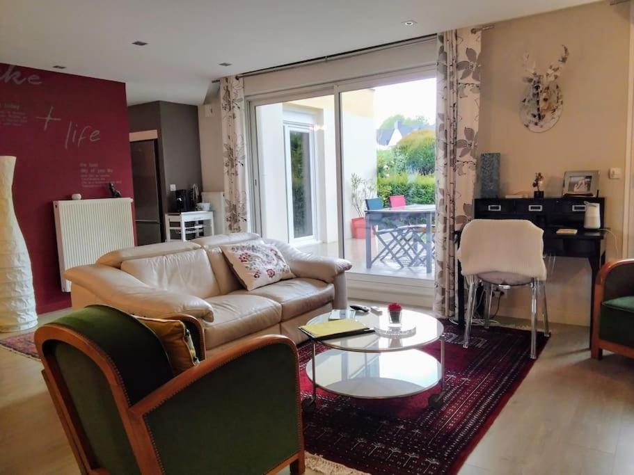 un salon avec un canapé et une table dans l'établissement Bel appartement avec terrasse, à Saint-Grégoire