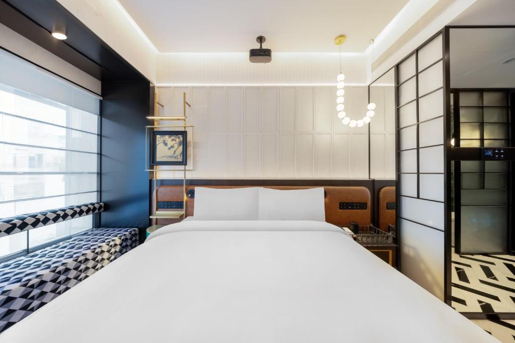 Postel nebo postele na pokoji v ubytování Beijing Tangfu Sanlitun BOUTIQUE Hotel---Breakfast, restaurant and bar, close to Tian'anmen Square Forbidden City Temple of Heaven, laundry, gym, robot, ticket service, located in city center Metro line 2, one station to Airport Express