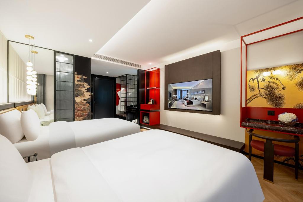 Postel nebo postele na pokoji v ubytování Beijing Tangfu Sanlitun BOUTIQUE Hotel---Breakfast, restaurant and bar, close to Tian'anmen Square Forbidden City Temple of Heaven, laundry, gym, robot, ticket service, located in city center Metro line 2, one station to Airport Express