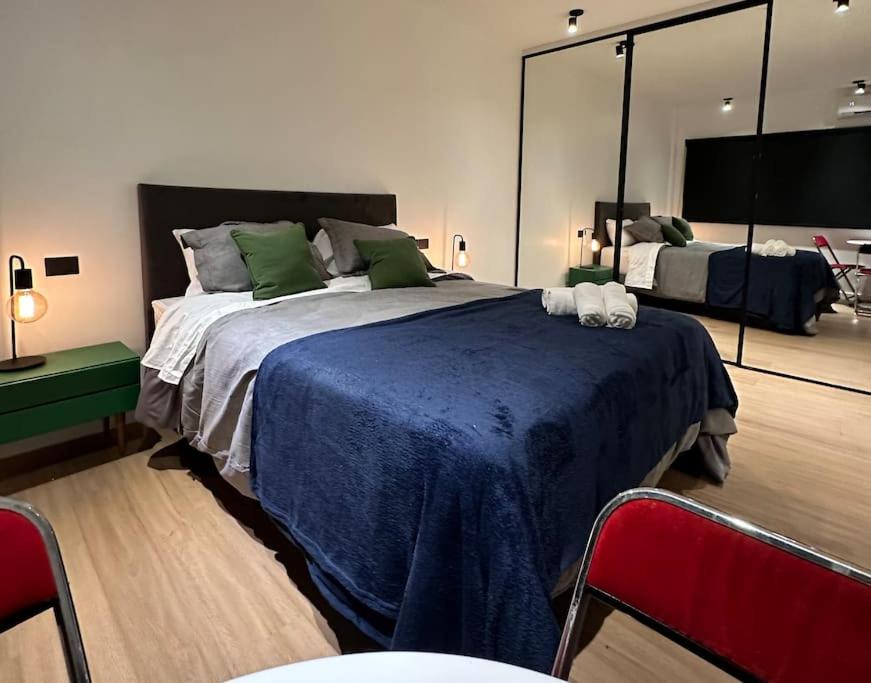 a bedroom with a large bed and a large mirror at Downtown Suite Self Check In in Buenos Aires