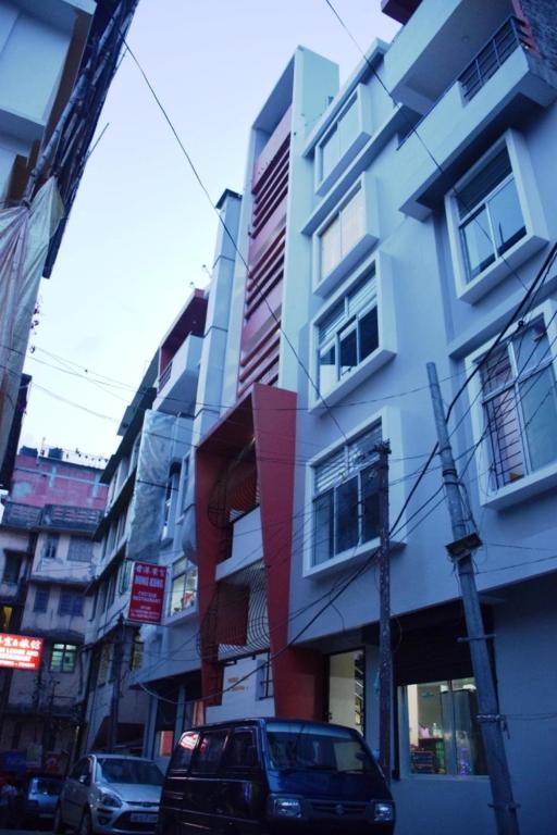 a car is parked in front of a building at Pokhrel Lodge in Kalimpong