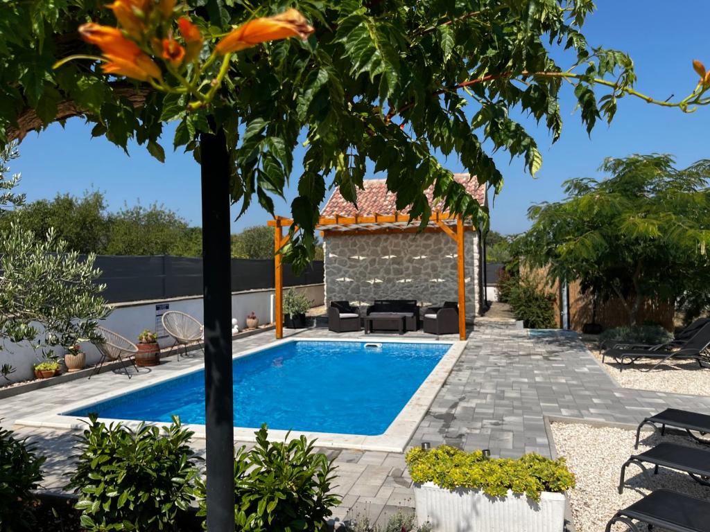 a swimming pool in a yard with a tree at Mediterranean Olive WaterfallsKRKA-Croatia in Gulin