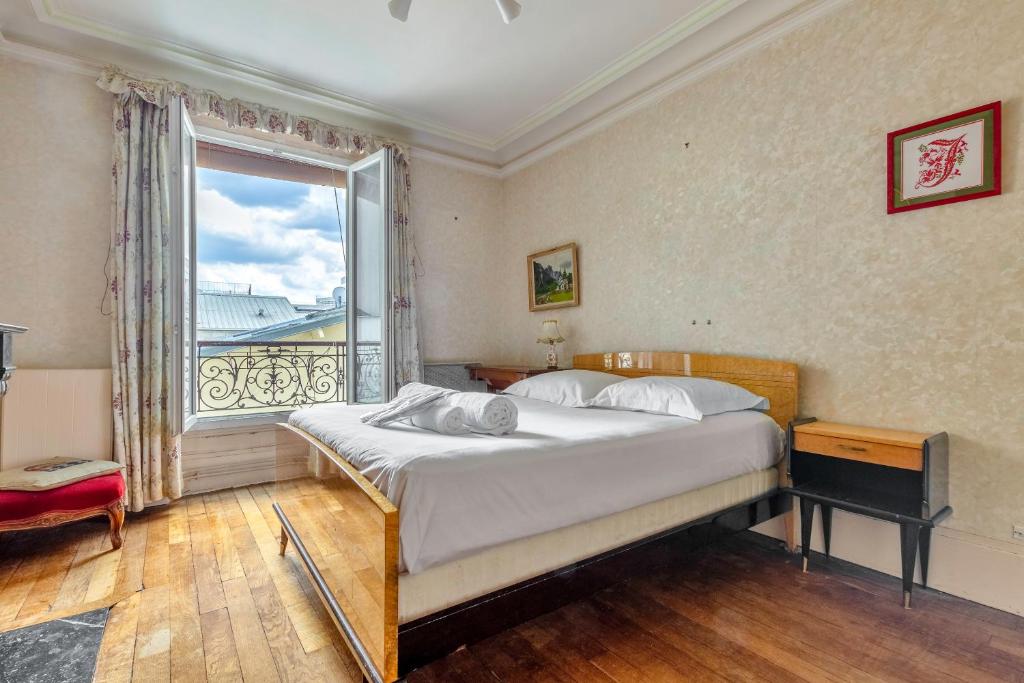 une chambre avec un lit et une grande fenêtre dans l'établissement Chanzy-Spacieux appartement familial Place de la Nation, à Paris