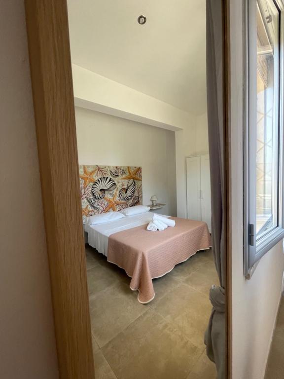a bedroom with a large bed with a pink blanket at Casa Vacanza Marijò in Sant'Isidoro