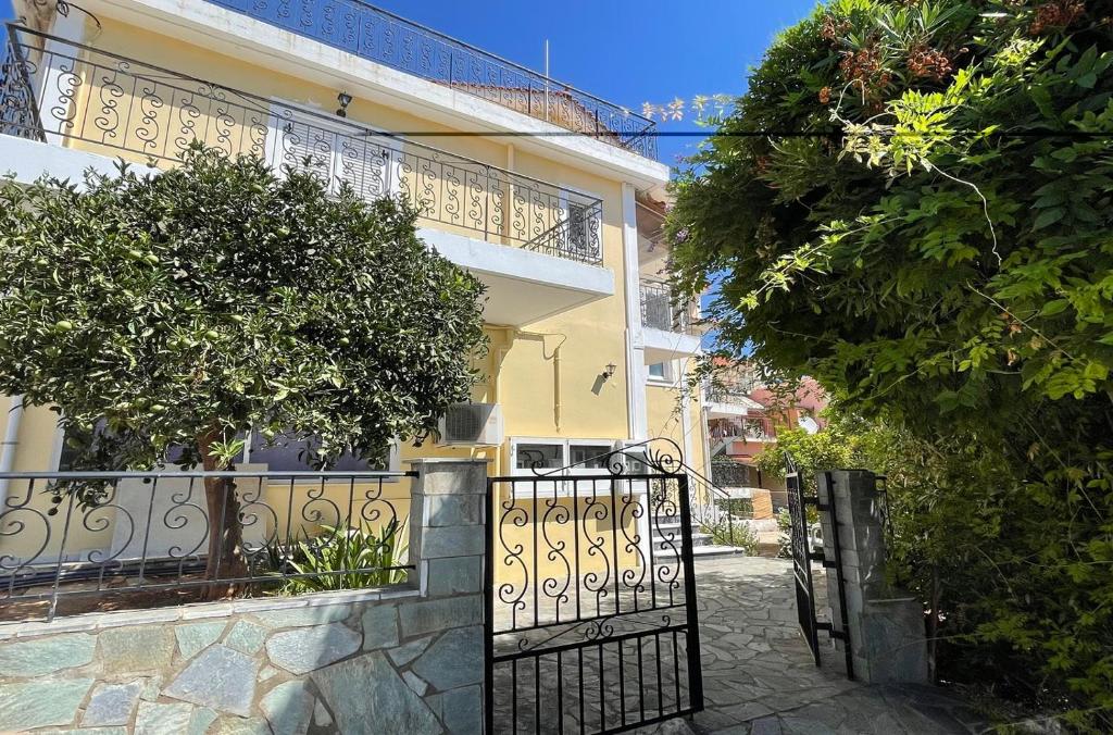 a yellow house with a gate in front of it at Mariannis Studios in Skala