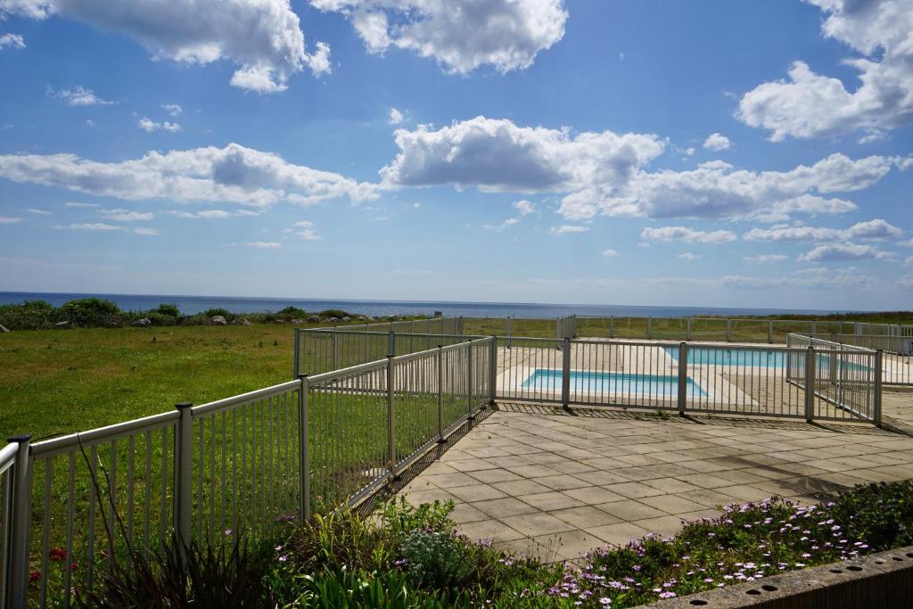 une clôture métallique avec une piscine dans un champ dans l'établissement Cabestan piscine 100m de la plage, à Guidel
