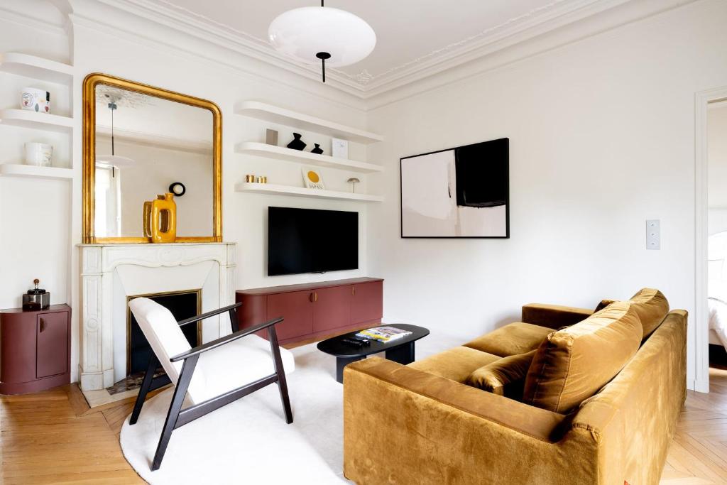 un salon avec un canapé et une cheminée dans l'établissement Appartement Latté - Welkeys, à Paris