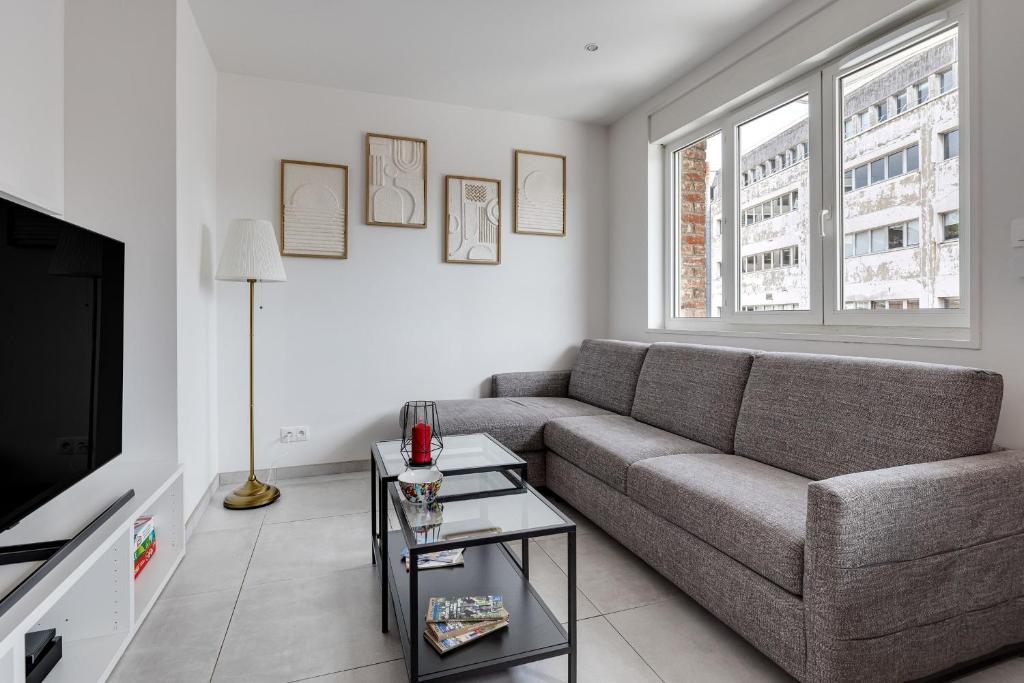 un salon avec un canapé et une télévision dans l'établissement Appartement Brivi - Welkeys, à Lille