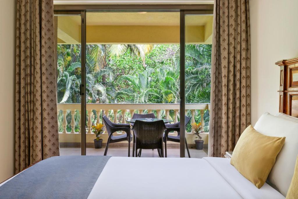Postel nebo postele na pokoji v ubytování De Mandarin Beach Resort Suites & Villas, Candolim