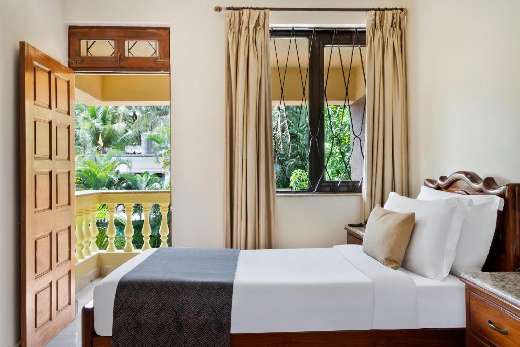Postel nebo postele na pokoji v ubytování De Mandarin Beach Resort Suites & Villas, Candolim