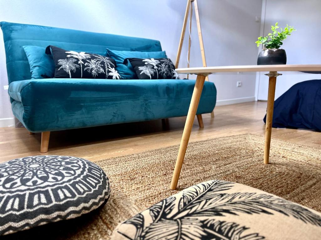 un salon avec un canapé bleu et une table dans l'établissement Appartement 3 chambres centre ville Cholet 25min du Puy duFou, à Cholet