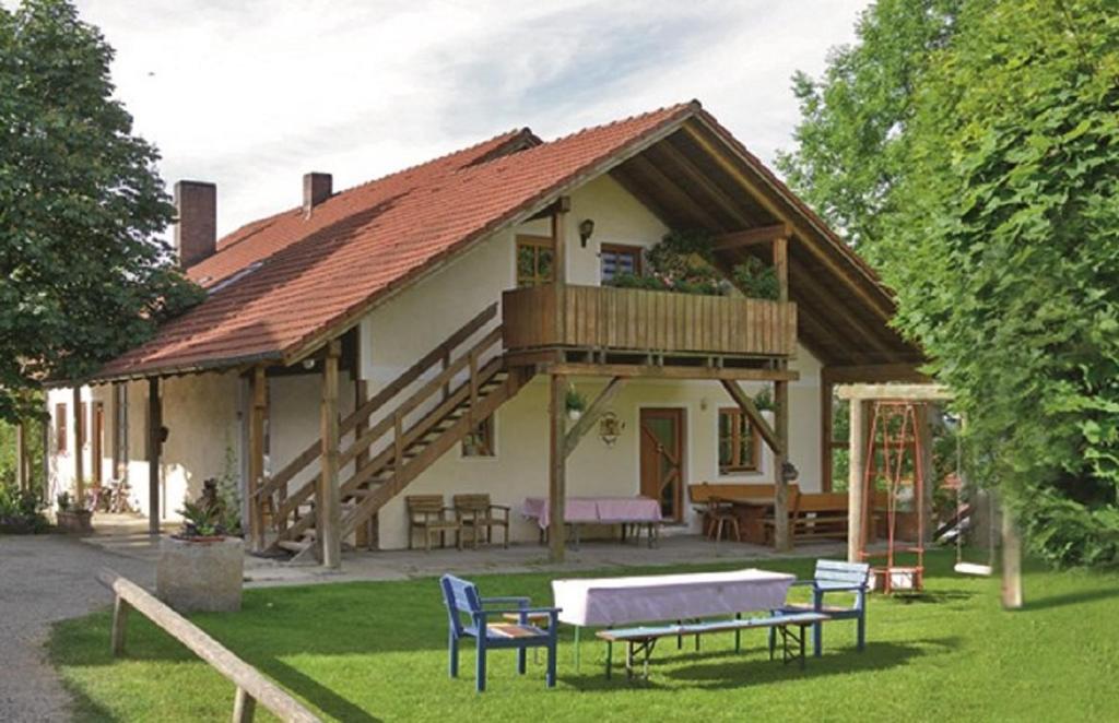 a house with a deck with a table and chairs at Ferienhof Beimler in Waldthurn