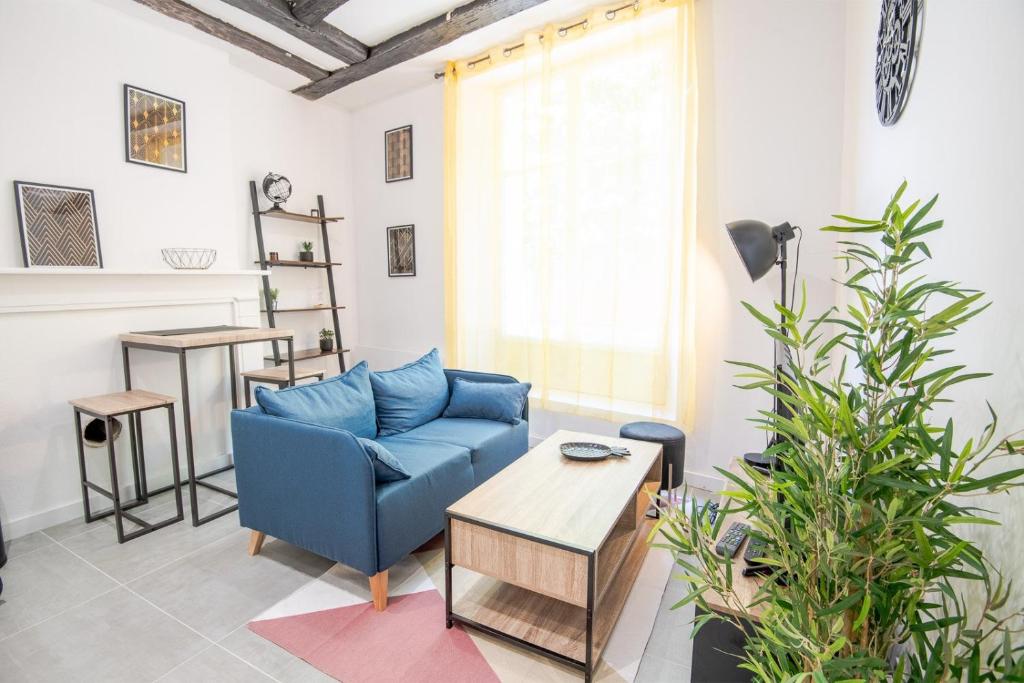 a living room with a blue couch and a table at La Cachette d'Amboise - Appart. 2 pers. in Amboise