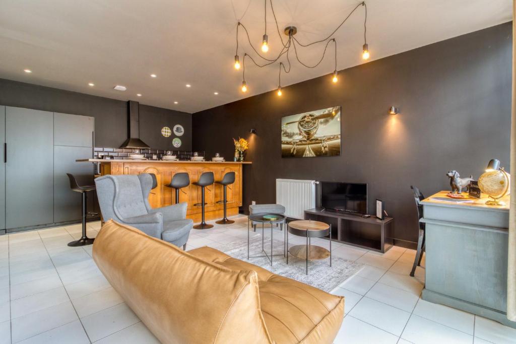 un salon avec un canapé et un bar dans l'établissement Le Gentleman - Elégant - Confort - Calme, à Douai