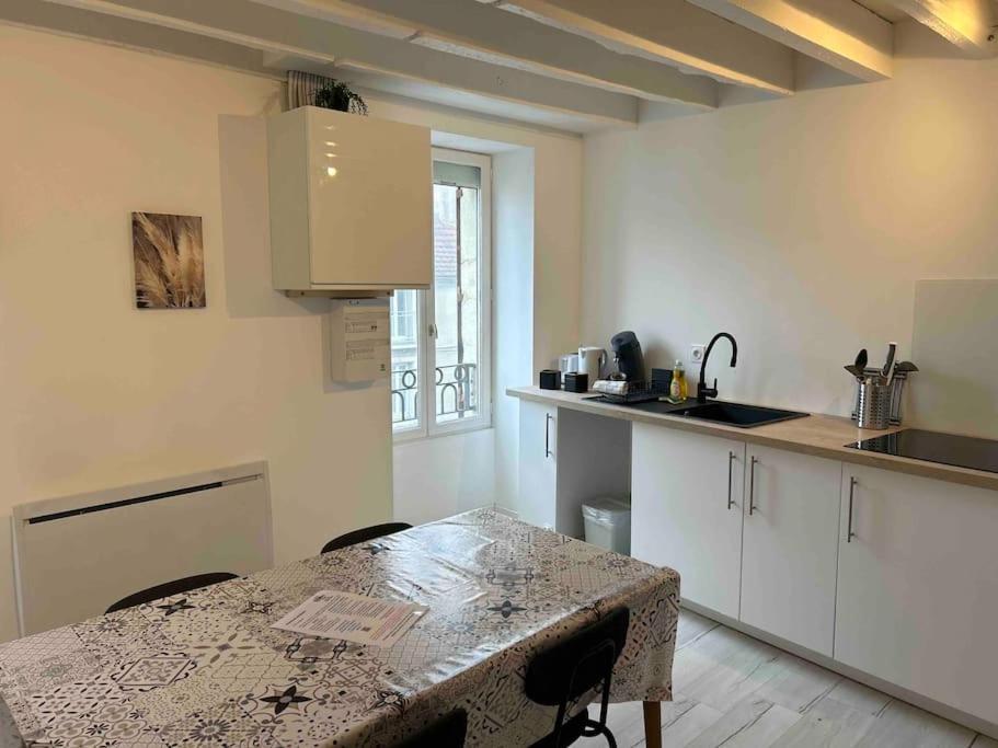 une cuisine avec une table et un comptoir dans l'établissement Le Voltaire, à Dijon