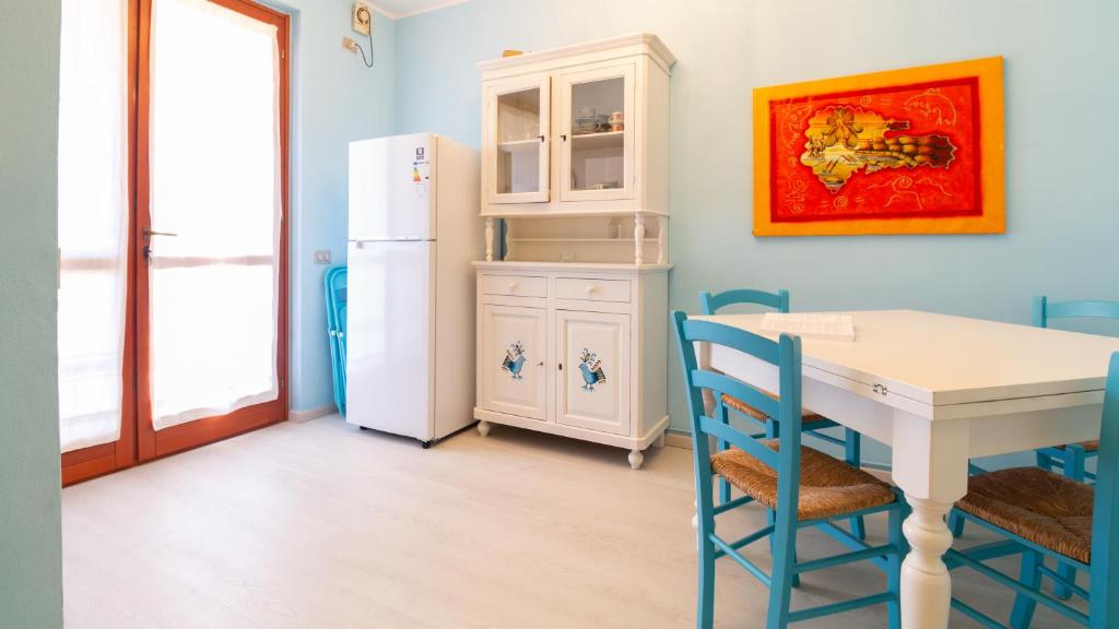 jadalnia ze stołem i lodówką w obiekcie Sardinianworld-Appartamento Azzurro w mieście Torre Grande
