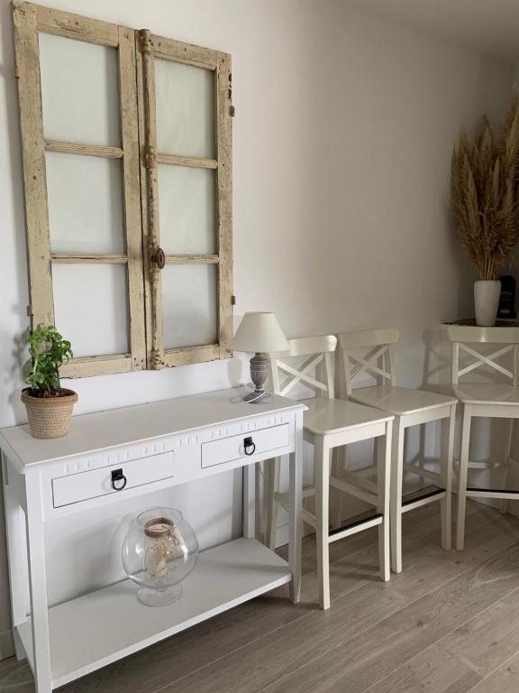 a white dressing table with a mirror and two chairs at Gite de Groupe Aux Instants Partagés in Fontenay-sur-Vègre
