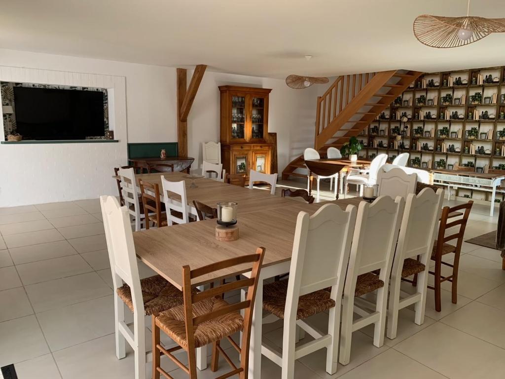 a dining room with a wooden table and chairs at Gite de Groupe Aux Instants Partagés in Fontenay-sur-Vègre