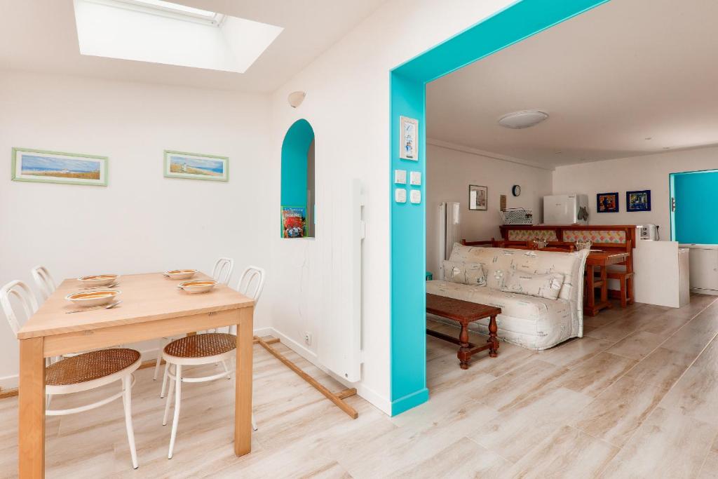 a dining room and living room with a table and chairs at À 350m du bord de mer, maison pour 4 in Saint-Pierre-Quiberon