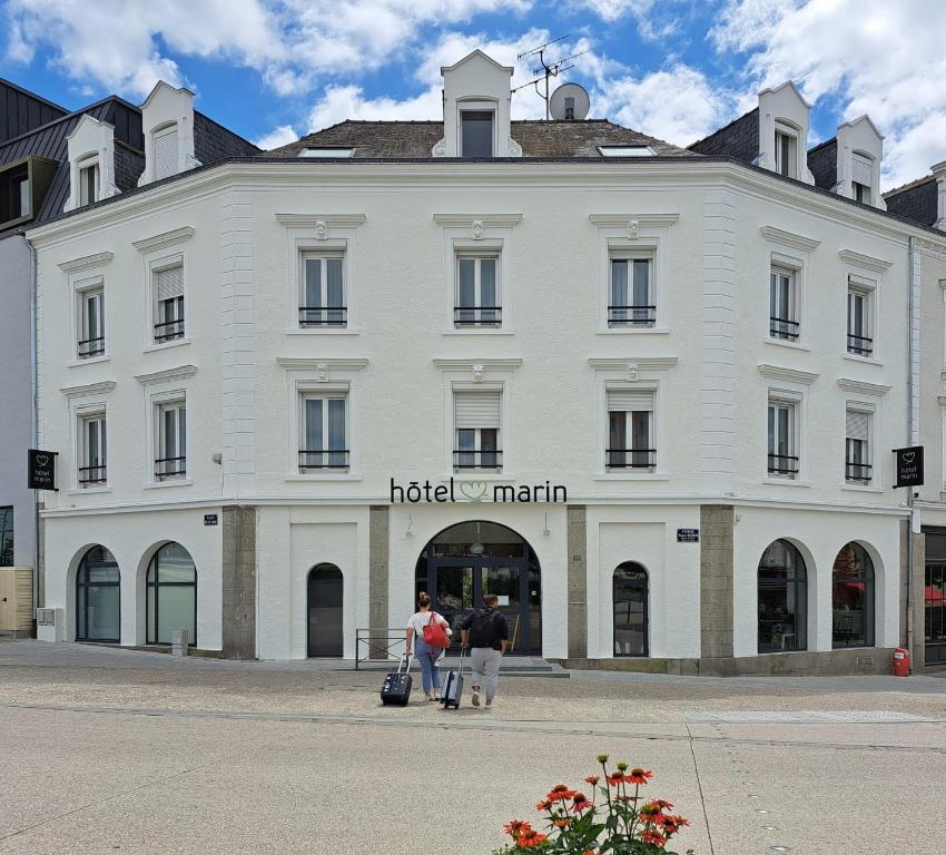 a large white building with people standing outside of it at Hôtel Marin in Laval