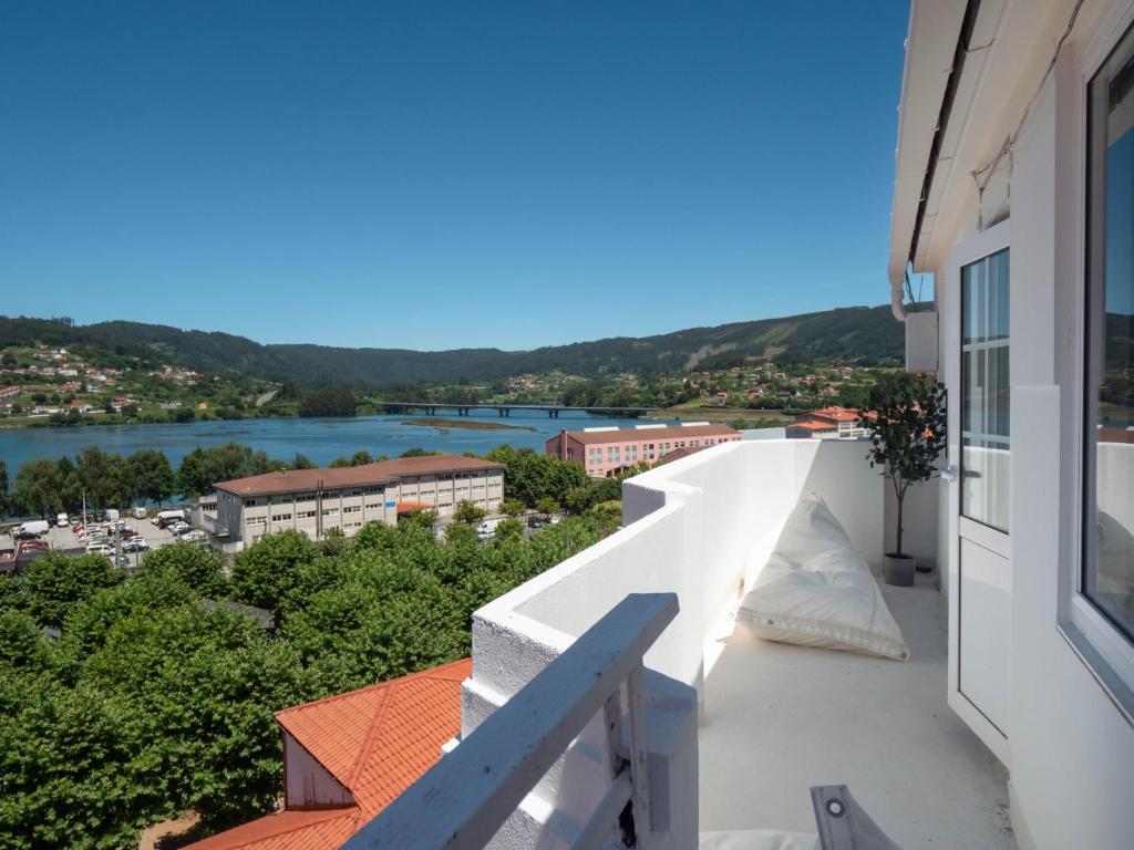 a balcony with a view of a river and buildings at La Fantástica Pontedeume 4 in Puentedeume