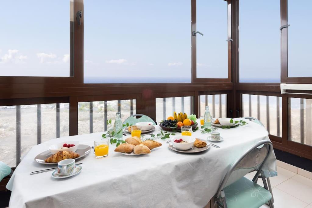 a table with plates of food and fruit on it at Volcanoes and Ocean Views in Arona
