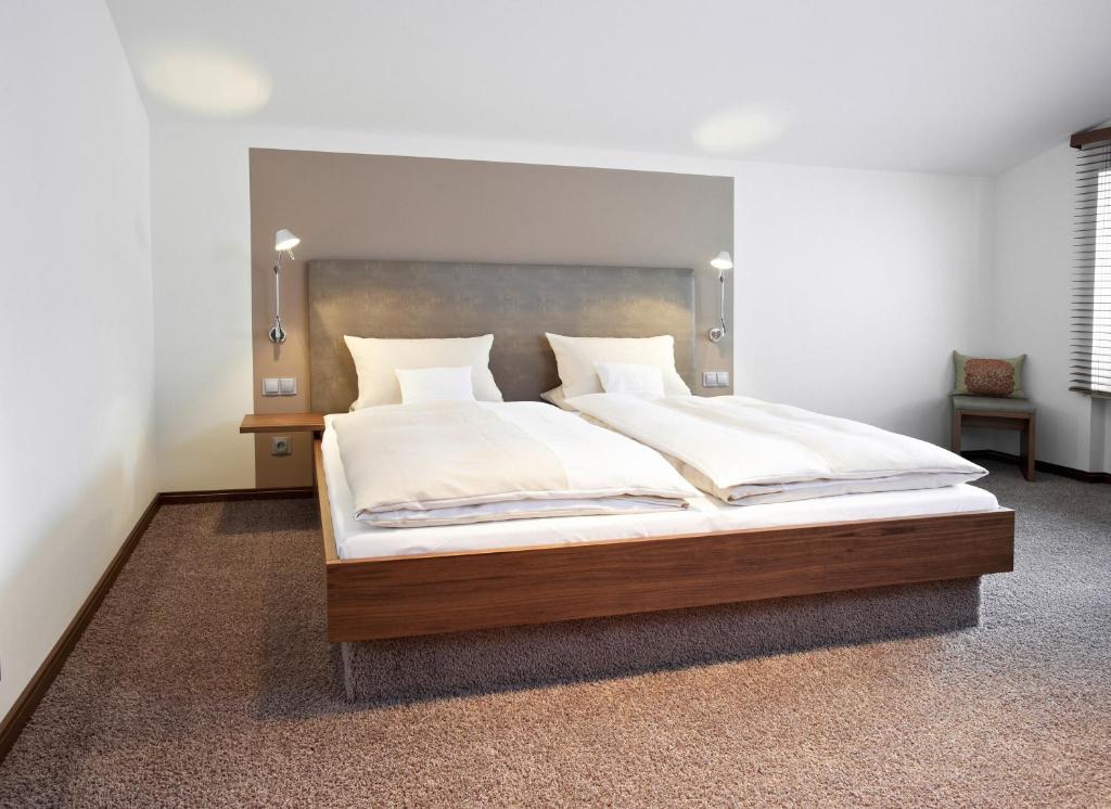 a bedroom with a large bed with white sheets at Hotel Am Helmwartsturm in Andernach