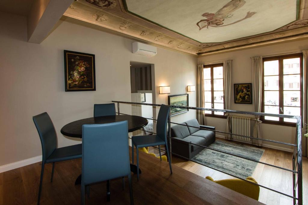 uma sala de estar com uma mesa e cadeiras e um tecto em Maison Alighieri em Florença